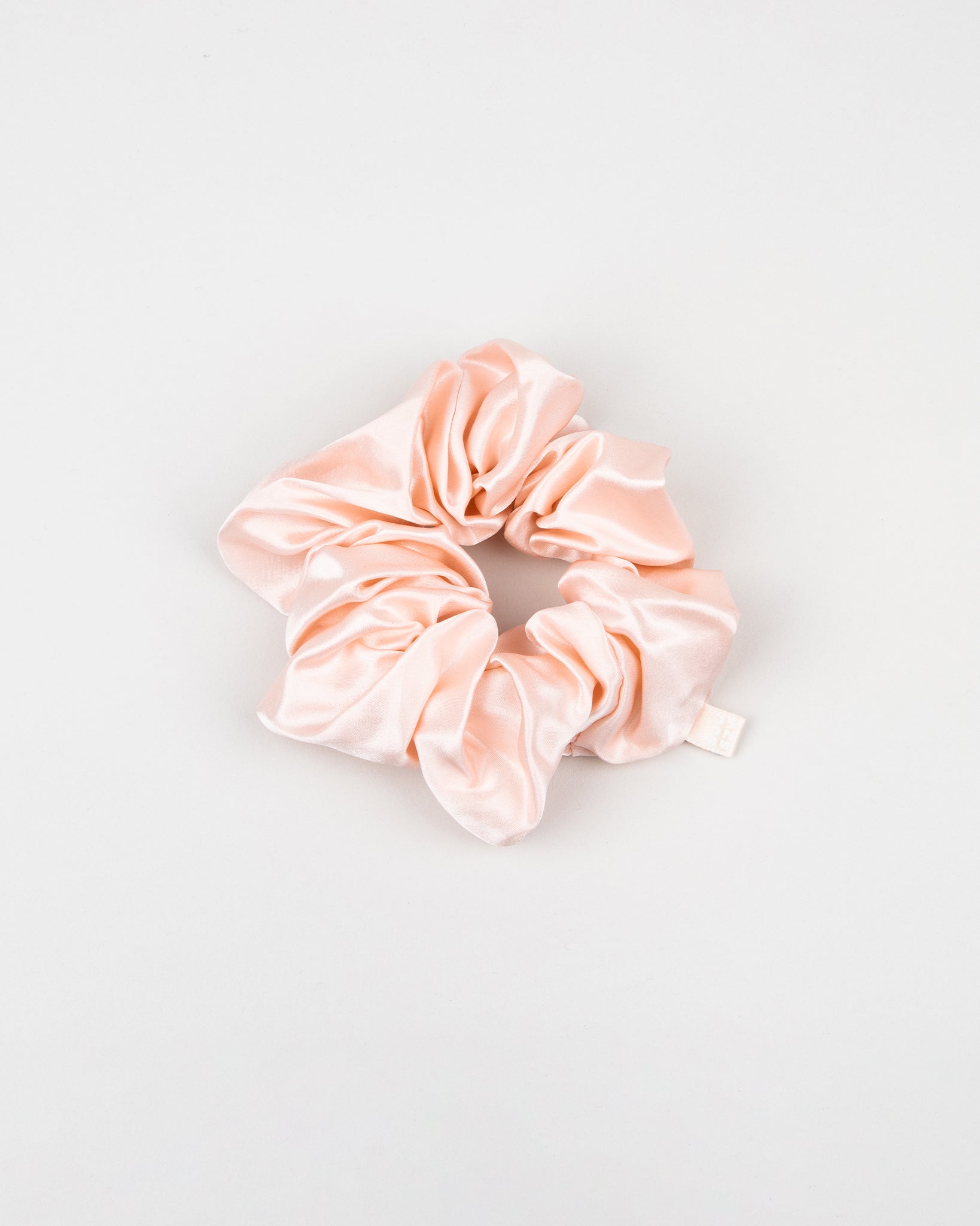 Large light pink silk scrunchie on a light gray background