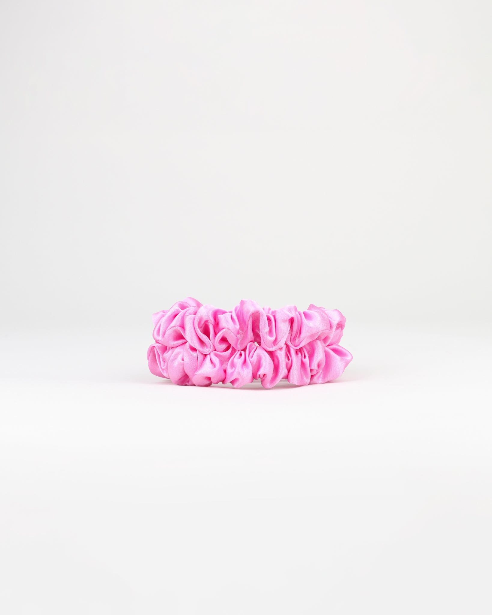 Two pink scrunchies on a white background