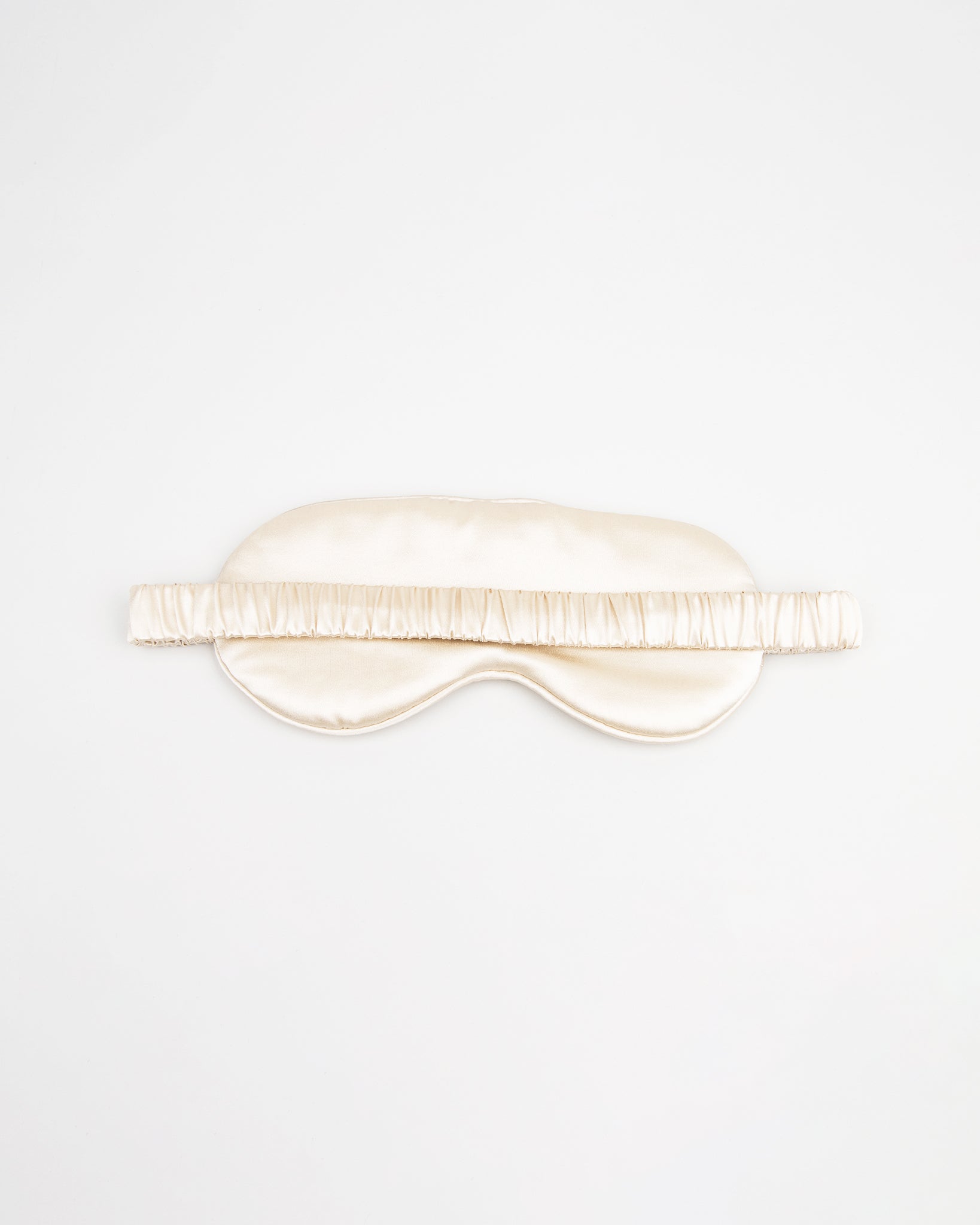 Beige silk eye mask on a white background