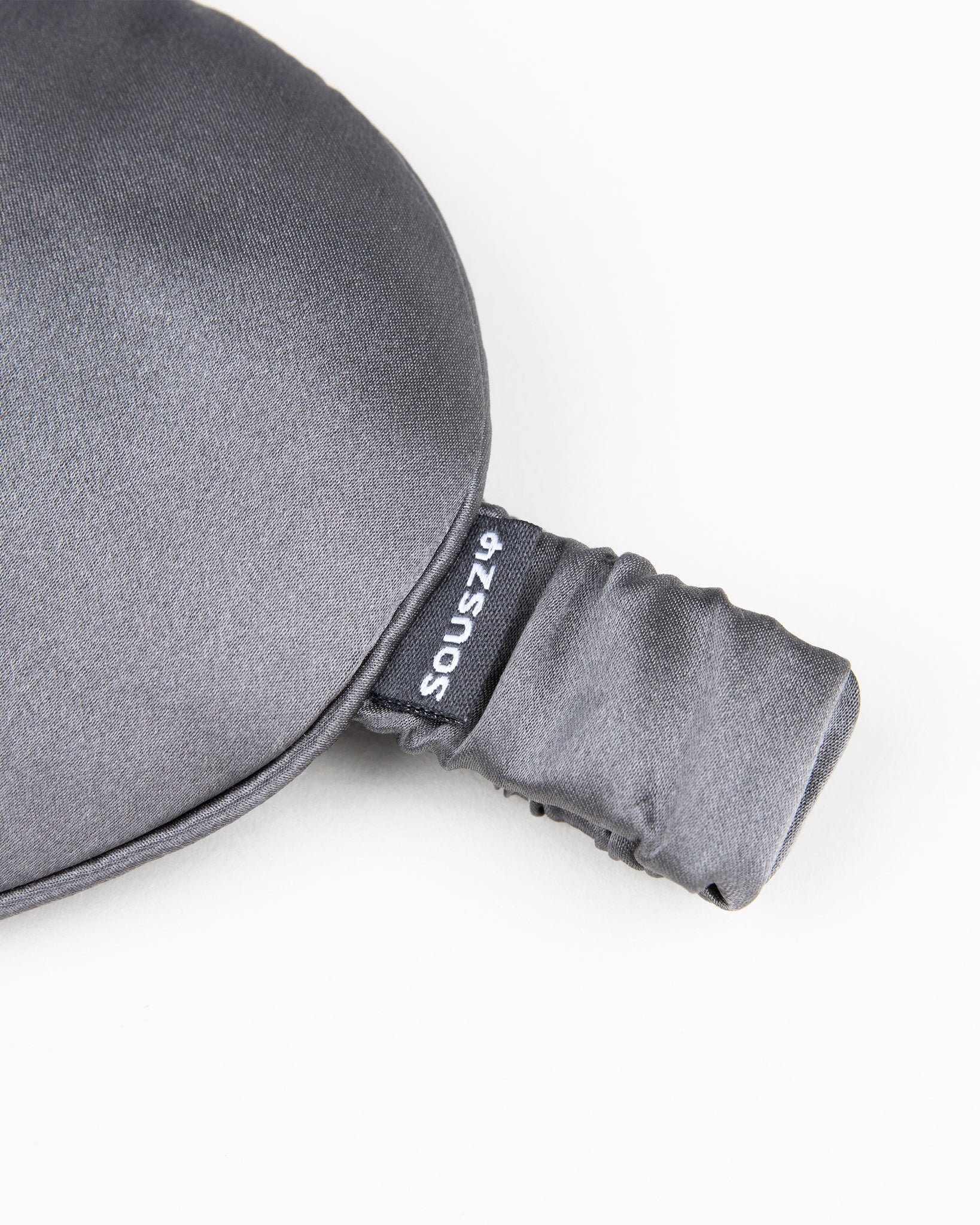 Gray silk sleep mask with a brand logo on a white background