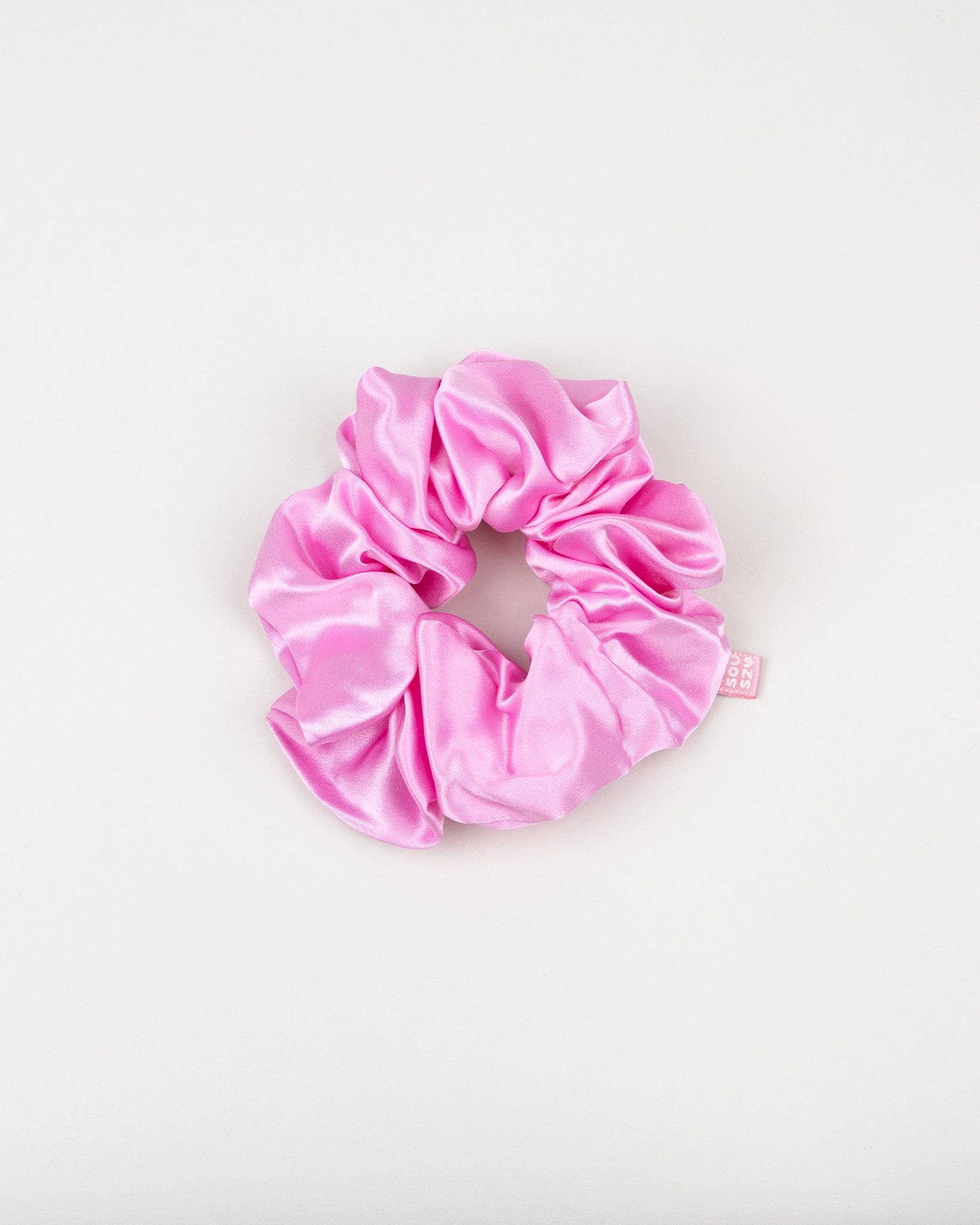 Large pink silk scrunchie on a white background