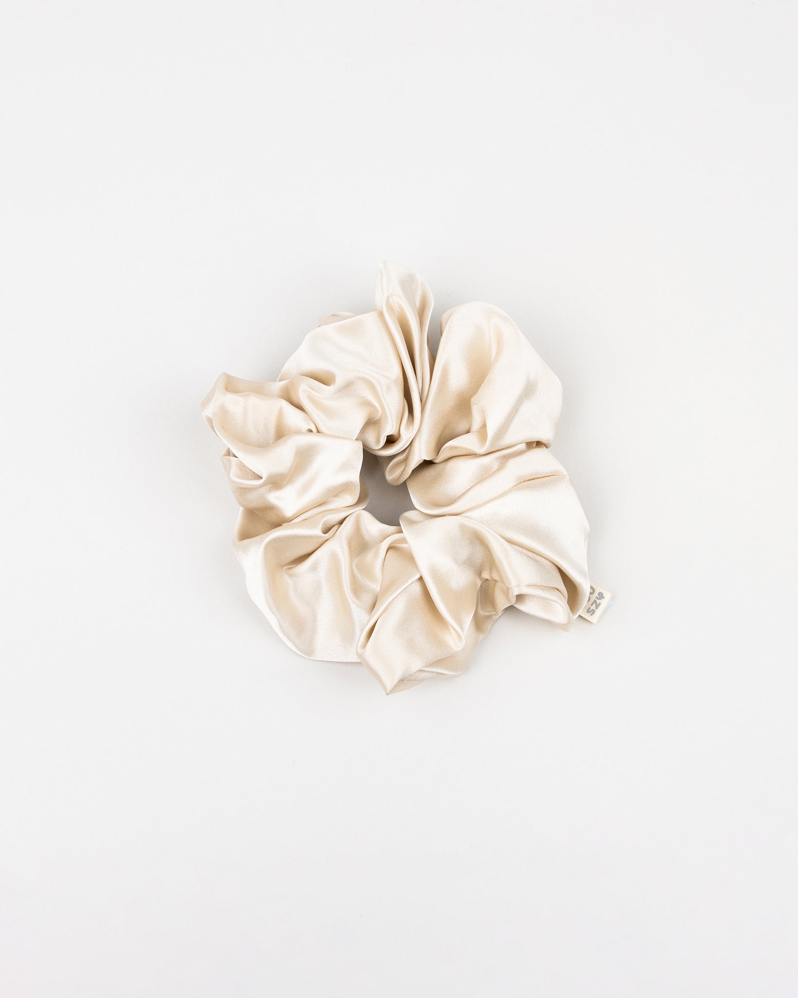 Large beige silk scrunchie on a white background
